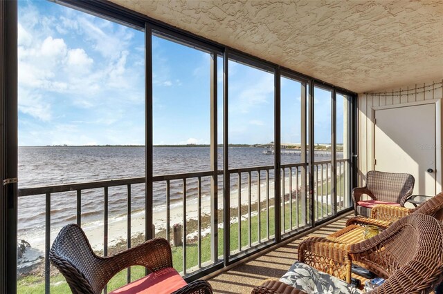 sunroom / solarium featuring a water view