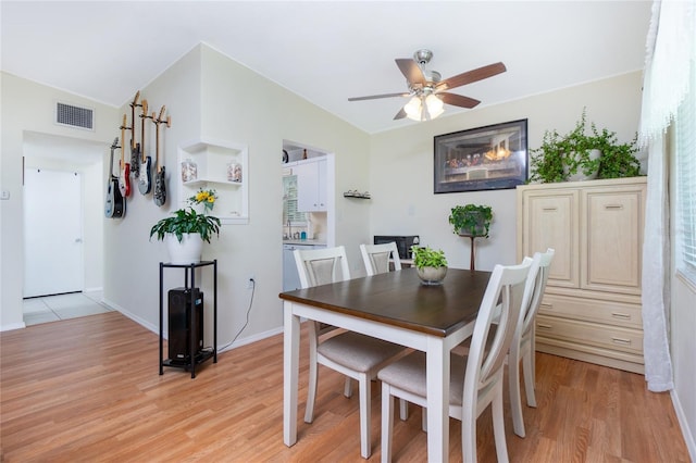 dining area with a ceiling fan, light wood-style floors, visible vents, and baseboards