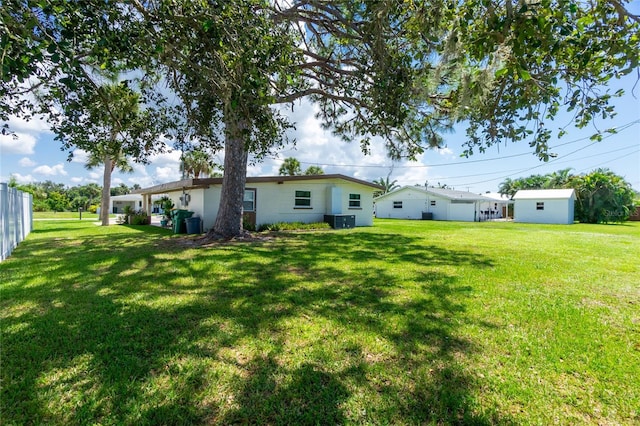 back of house with a lawn, cooling unit, and fence