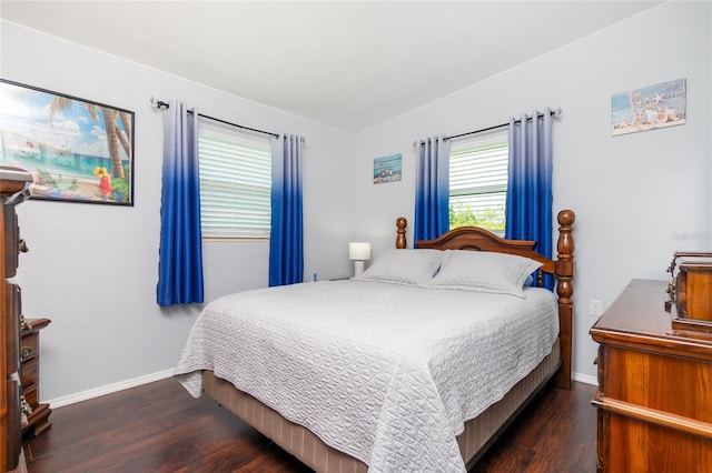 bedroom with lofted ceiling, wood finished floors, and baseboards