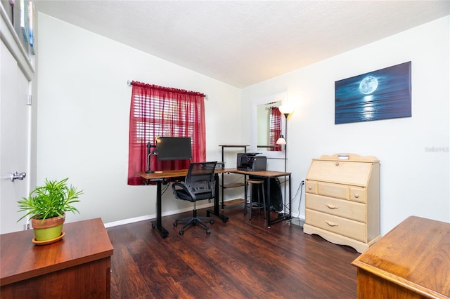 office space featuring vaulted ceiling, baseboards, and wood finished floors