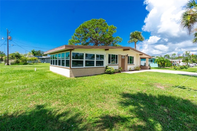 view of front of home featuring concrete driveway and a front lawn