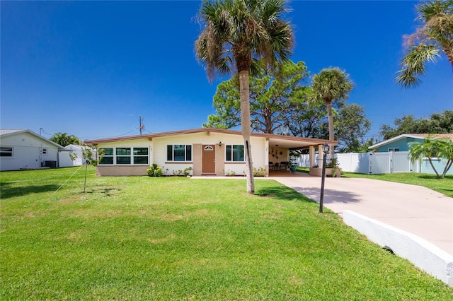 single story home featuring an attached carport, concrete driveway, a front lawn, and fence