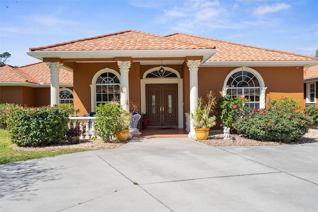 doorway to property with stucco siding and a tile roof