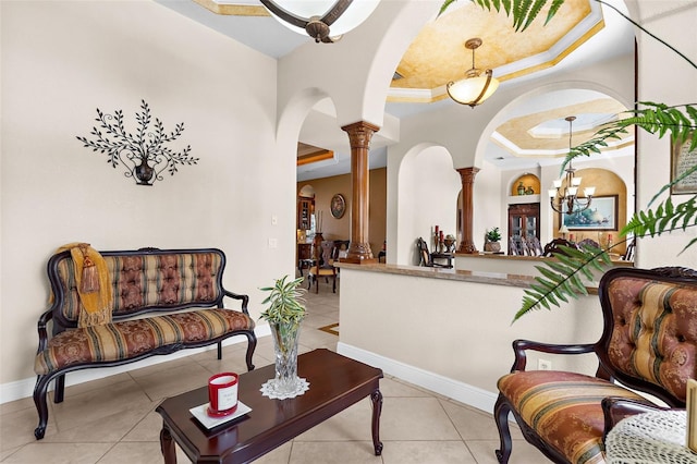 living room with arched walkways, light tile patterned flooring, a tray ceiling, and decorative columns