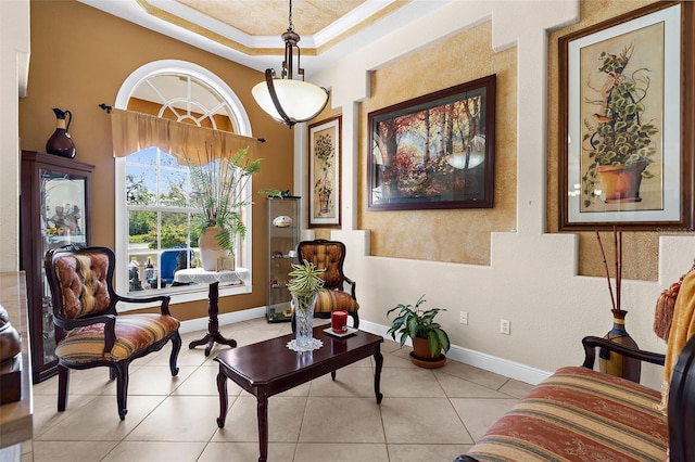 sitting room featuring tile patterned floors, baseboards, crown molding, and a tray ceiling