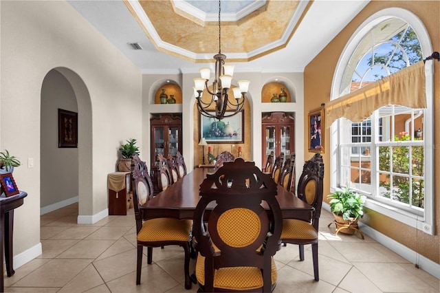 dining area with visible vents, ornamental molding, arched walkways, an inviting chandelier, and a raised ceiling