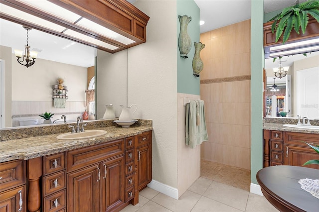 full bath featuring tile patterned flooring, a chandelier, and vanity