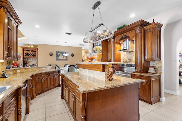 kitchen featuring visible vents, a kitchen island, arched walkways, appliances with stainless steel finishes, and light tile patterned floors