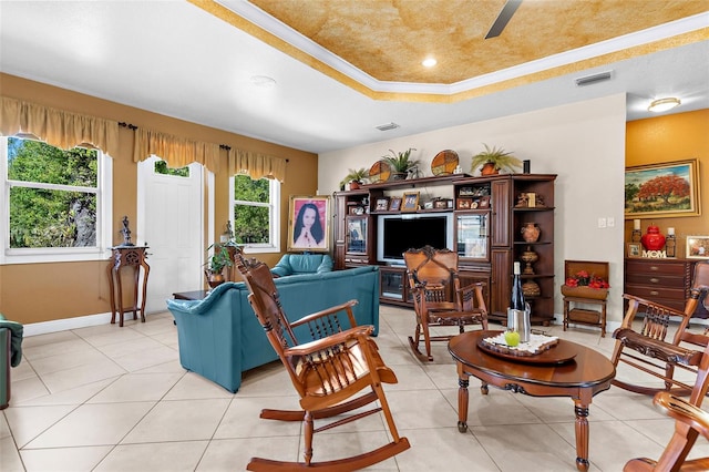 living area featuring a raised ceiling, light tile patterned flooring, baseboards, and visible vents