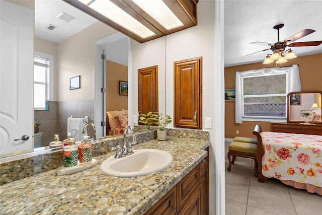 bathroom featuring a textured ceiling, ceiling fan, vanity, and tile patterned flooring