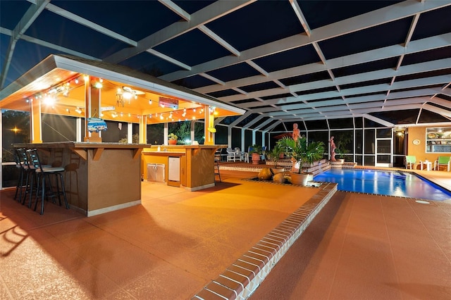 outdoor pool featuring a sink, glass enclosure, a patio, and outdoor dry bar