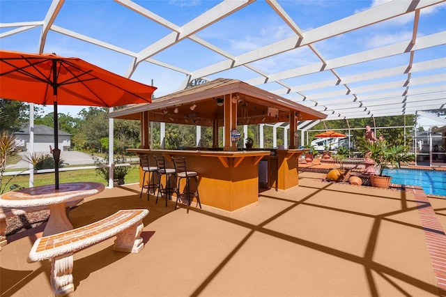 view of patio / terrace with an outdoor pool, a lanai, and outdoor dry bar