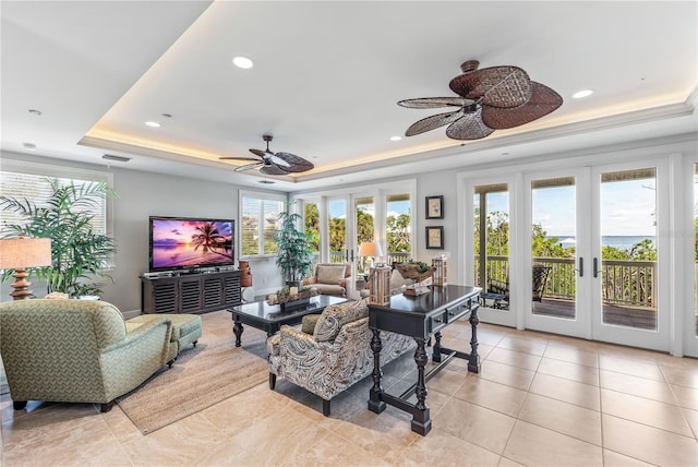 living area with a raised ceiling, light tile patterned floors, french doors, and visible vents