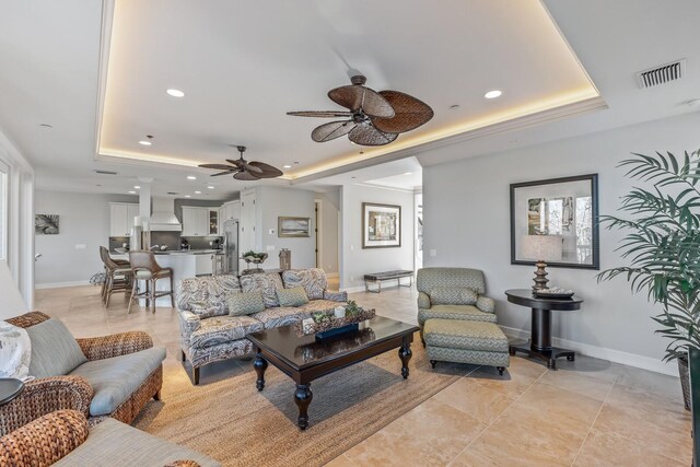 living area featuring recessed lighting, a raised ceiling, and baseboards