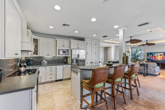 kitchen featuring stainless steel appliances, dark countertops, and visible vents