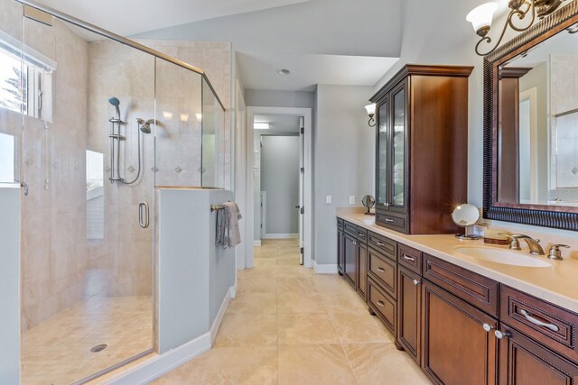 full bathroom with a sink, a stall shower, double vanity, and tile patterned flooring