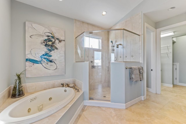 bathroom with a shower stall, a jetted tub, baseboards, and vaulted ceiling