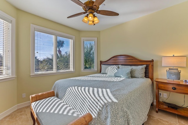 tiled bedroom featuring baseboards and a ceiling fan