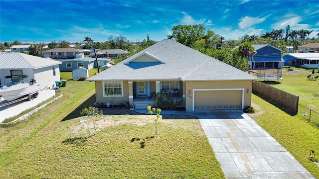 view of front of property with a front yard, fence, driveway, an attached garage, and stucco siding