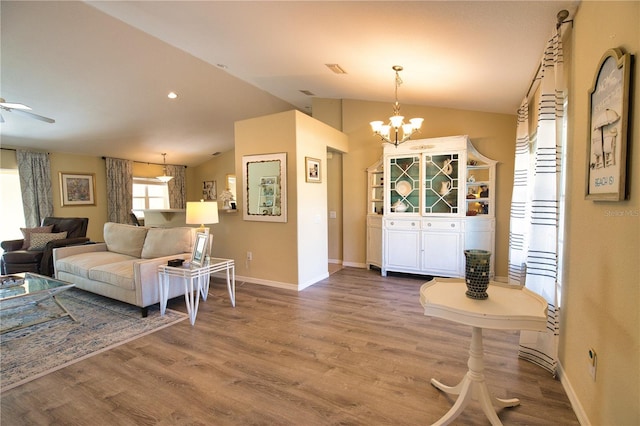 entryway with ceiling fan with notable chandelier, baseboards, lofted ceiling, and wood finished floors