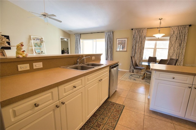 kitchen featuring a sink, stainless steel dishwasher, white cabinetry, light tile patterned floors, and lofted ceiling