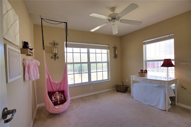 carpeted bedroom featuring multiple windows, baseboards, and ceiling fan