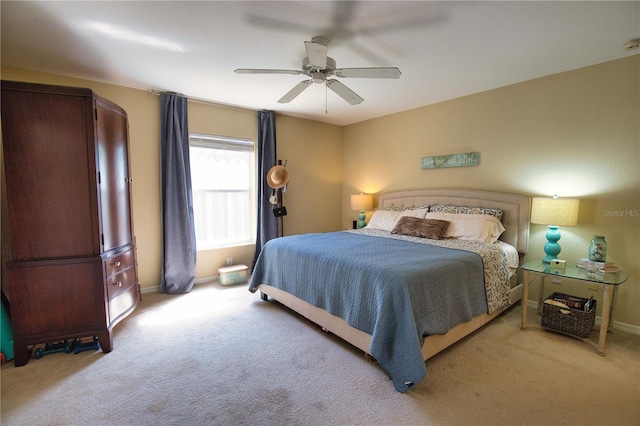 bedroom featuring light carpet, baseboards, and a ceiling fan