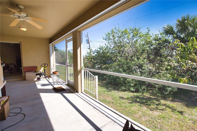 unfurnished sunroom with a ceiling fan