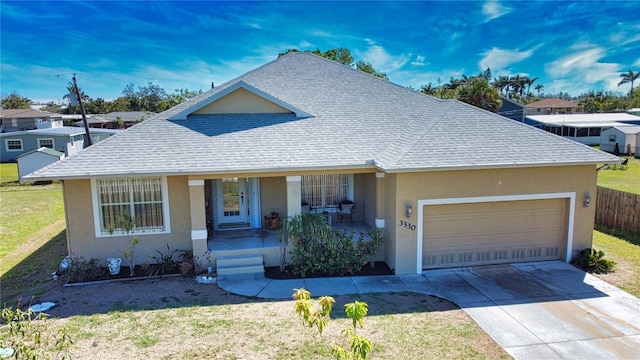 view of front of house featuring stucco siding, driveway, covered porch, a shingled roof, and a garage