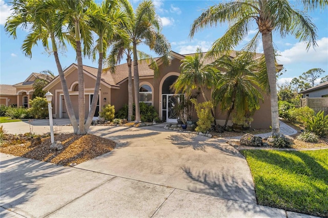 view of front of property with stucco siding, a garage, and driveway