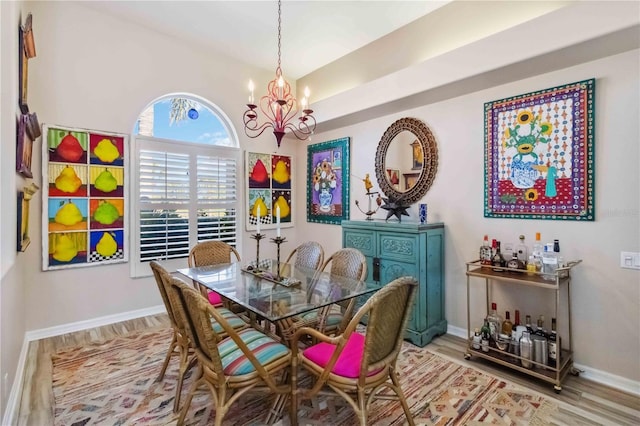 dining area with a notable chandelier, baseboards, and wood finished floors