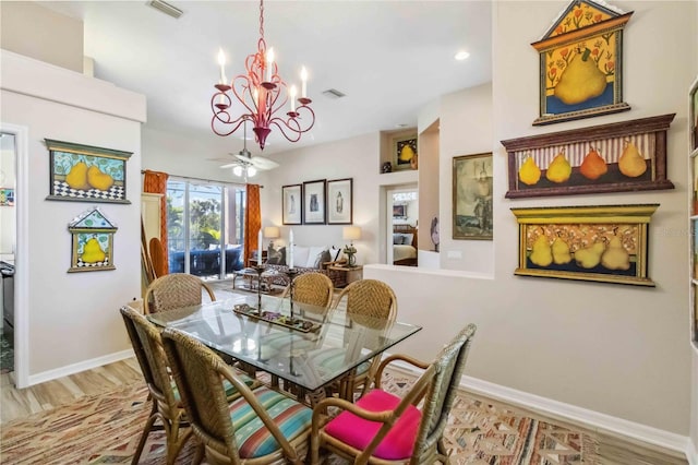 dining room with ceiling fan with notable chandelier, baseboards, visible vents, and light wood finished floors