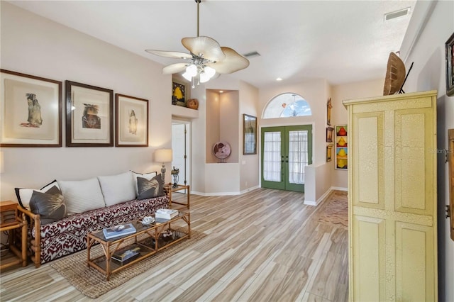 living area featuring a ceiling fan, visible vents, baseboards, french doors, and light wood-style floors