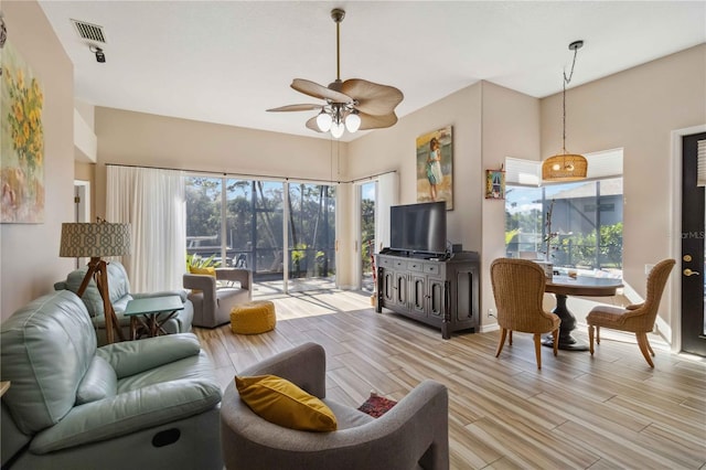 living room with visible vents, light wood-style flooring, and ceiling fan