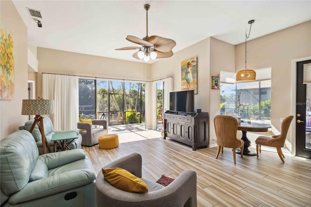 living area with light wood-style floors, visible vents, and ceiling fan