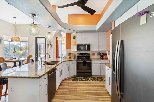 kitchen with a sink, stainless steel appliances, a peninsula, white cabinets, and ceiling fan