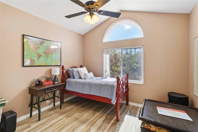 bedroom featuring light wood finished floors, baseboards, and vaulted ceiling