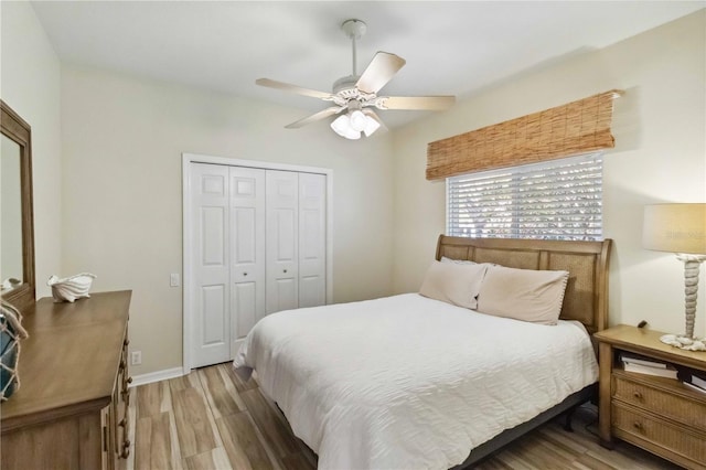 bedroom with a closet, baseboards, wood finished floors, and a ceiling fan