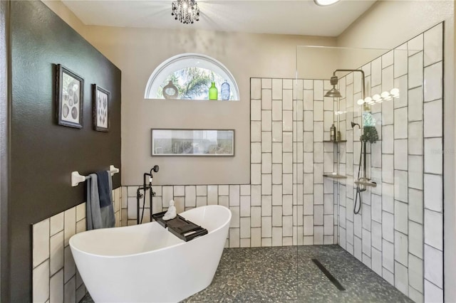 bathroom featuring tile walls, a freestanding tub, and walk in shower