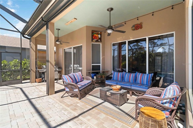 view of patio / terrace featuring area for grilling, glass enclosure, outdoor lounge area, and a ceiling fan