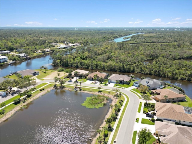 bird's eye view featuring a residential view, a wooded view, and a water view