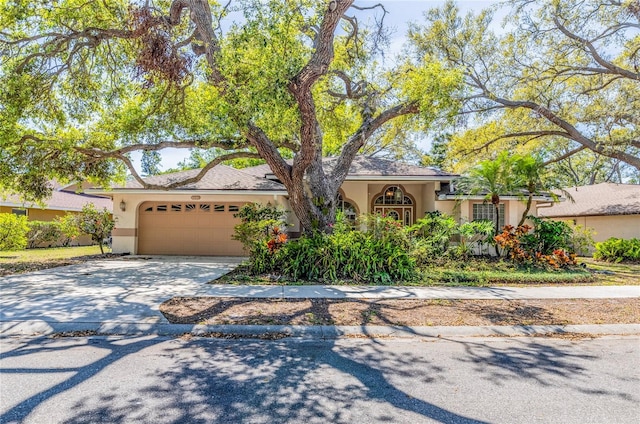 view of front of home featuring stucco siding, an attached garage, and concrete driveway