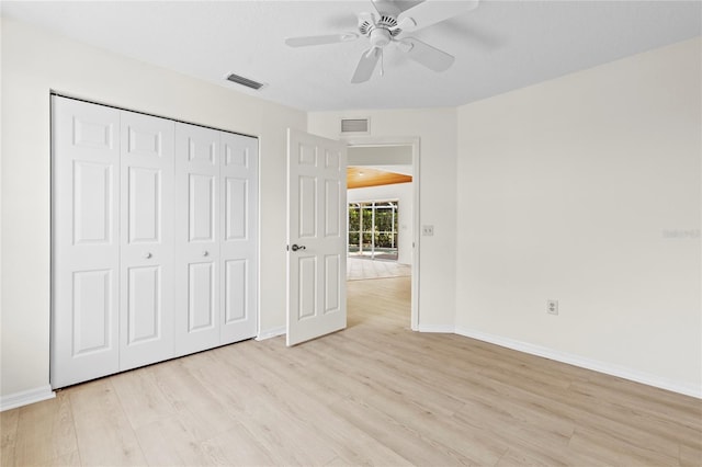 unfurnished bedroom with light wood-type flooring, visible vents, baseboards, and a closet