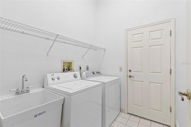 laundry area featuring a sink, light tile patterned floors, laundry area, and washer and dryer