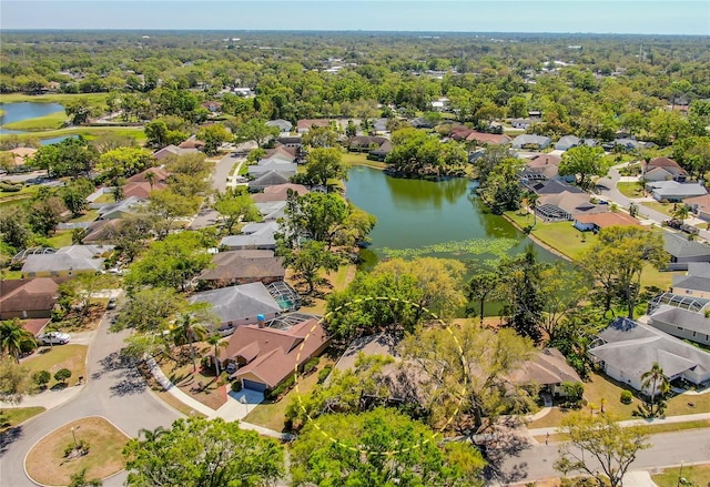 birds eye view of property with a residential view, a wooded view, and a water view