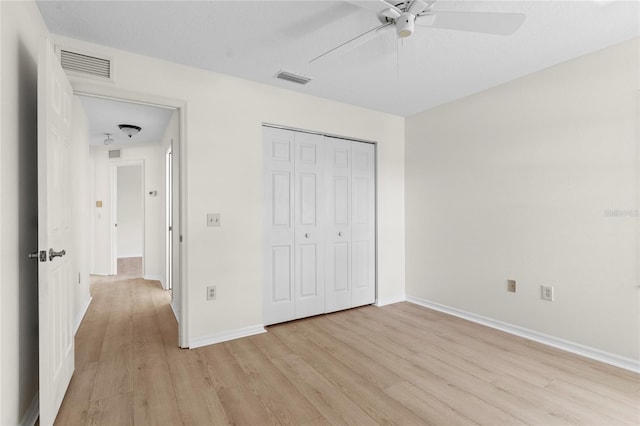 unfurnished bedroom with a closet, baseboards, visible vents, and light wood finished floors