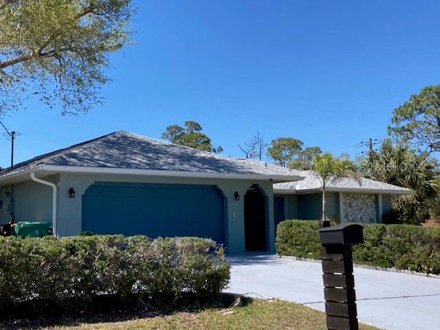 single story home with concrete driveway, a garage, and stucco siding