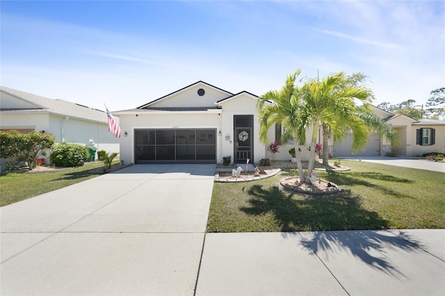 view of front facade featuring a front lawn, an attached garage, driveway, and stucco siding