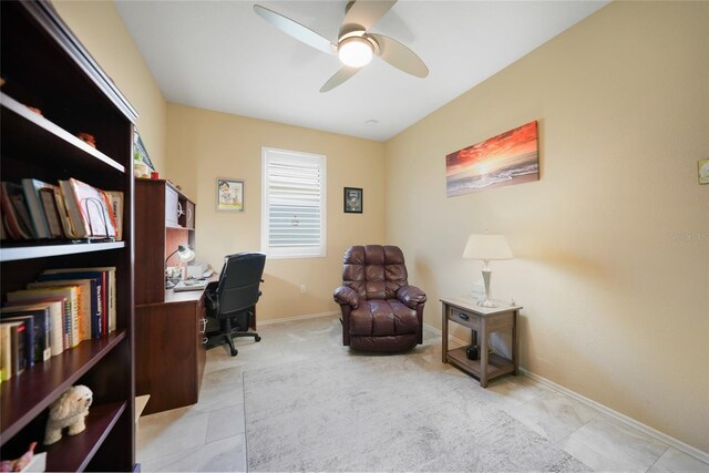 tiled office space with a ceiling fan and baseboards